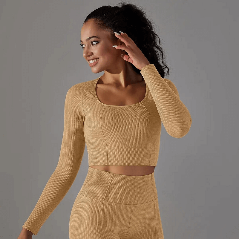 Woman wearing seamless bodycon crop top with long sleeves, ideal for yoga and cycling, in a breathable nylon-spandex blend.